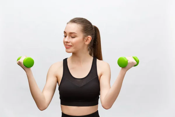 Happy fitness vrouw heffen halters glimlachend vrolijk, fris en energiek. Kaukasische fitness meisje training geïsoleerd op witte achtergrond. — Stockfoto