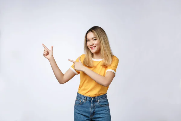 Bela jovem ásia mulher apontando ela dedo para cima com alegre expressão no branco fundo . — Fotografia de Stock