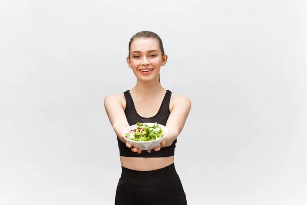 Saludable mujer fitness comer ensalada y de pie, aislado sobre fondo blanco . —  Fotos de Stock