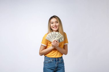 Beyaz arka planda izole nakit notlar tutan Asyalı kadın. Beyaz t-shirt kazanan sürpriz, doları not tutan Genç Asyalı kadın. Genç zengin hipster kavramı.