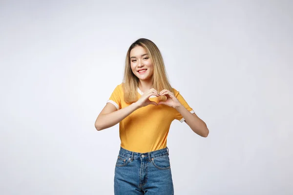 Bir kalp yapma genç ve güzel Asyalı kadın parmaklarını göğsünün önünde hareketini — Stok fotoğraf