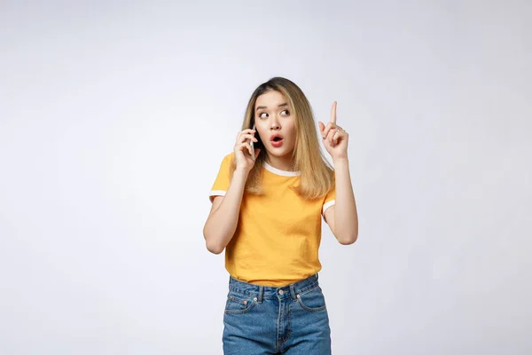 Ritratto di una giovane donna asiatica pensierosa che tiene il telefono cellulare e distoglie lo sguardo dal pensare isolato su sfondo bianco — Foto Stock