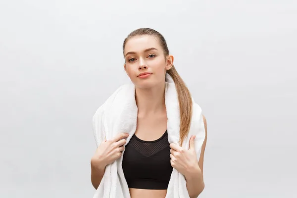 Zdravé krásné sportovkyněžena na sobě teplákové soupravy s ručníkem hledá izolované přes šedé pozadí — Stock fotografie