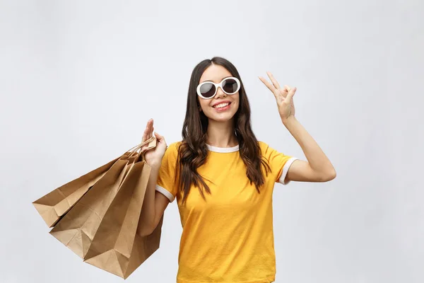 Junge schöne Shopperin mit Einkaufstüten zeigt zwei Finger. isolierter weißer Hintergrund — Stockfoto