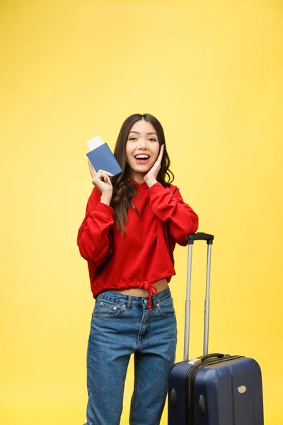 Cestování žen. Mladá krásná asijská žena cestovatel s kufrem a cestovním pasem na žlutém pozadí — Stock fotografie