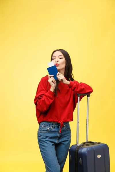 Una mujer viajando. Joven hermosa mujer asiática viajero con maleta y pasaporte sobre fondo amarillo — Foto de Stock