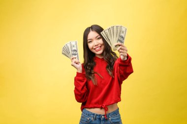 Genç ve güzel bir kadının yakın plan fotoğrafı. Para elimizin altında. Sarı arka plan, fotokopi alanı.