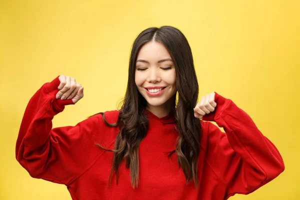 Retrato de una mujer asiática feliz bailando aislada sobre fondo amarillo —  Fotos de Stock