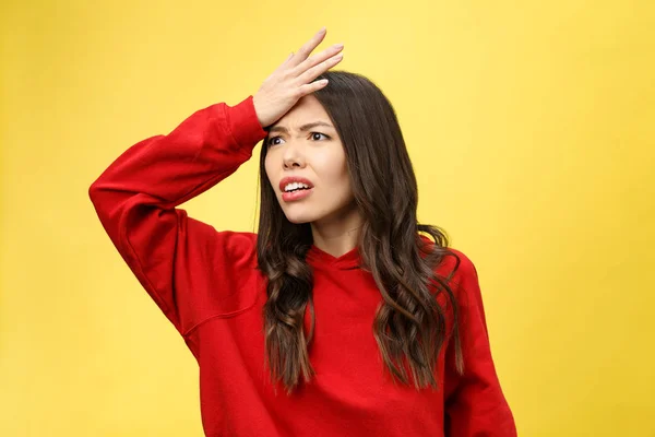 Impresionada hermosa mujer joven asustada con la boca ampliamente abierta, mira fijamente a la cámara se da cuenta de que decepciona con algo, aislado sobre el fondo del estudio amarillo . —  Fotos de Stock