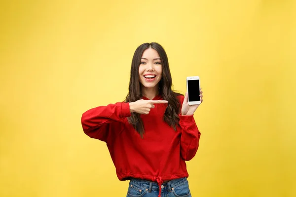 Portret Wesołej Dziewczyny Trzymającej Telefon Komórkowy Wskazującej Palcem Żółtym Tle — Zdjęcie stockowe