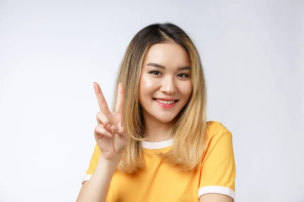 Happy young asian woman showing two fingers or victory gesture with blank copyspace area for text,Portrait of beautiful Asian woman. — Stock Photo, Image