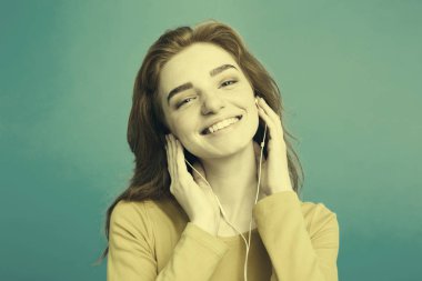 Yaşam Tarzı Konsepti - Cep telefonundan müzik dinleyen güzel Afro-Amerikan kadın portresi. Sarı pastel stüdyo arka planı. Boşluğu Kopyala