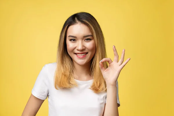 Asiática joven mujer con ok signo gesto aislar sobre amarillo fondo . — Foto de Stock
