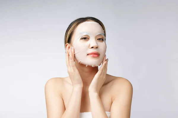 얼굴에 흰색 종이로 된 마스크를 쓰고 있는 아름다운 아시아 여인 — 스톡 사진