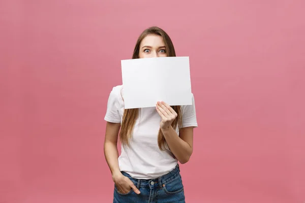 Jeune femme caucasienne tenant une feuille de papier vierge sur fond isolé effrayée en état de choc avec un visage surprise, effrayée et excitée par l'expression de la peur — Photo