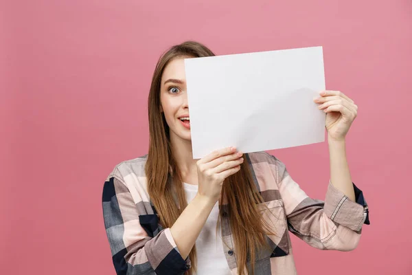 Ung kaukasisk kvinna håller blankt papper ark över isolerad bakgrund rädd i chock med en överraskning ansikte, rädd och upphetsad med rädsla uttryck — Stockfoto