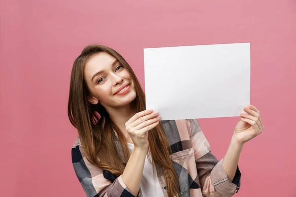 Close up portrait of positive laughing woman smiling and holding white big mockup poster isolated on pink background — Stock Photo, Image