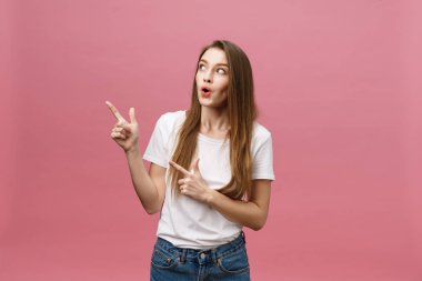 Kadın kamerayı işaret ediyor ve dişlek gülümsüyor. İfade duygusu ve duygular kavramı. Stüdyo çekimi, pembe arka planda izole edilmiş.