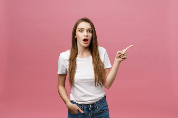 Mujer señalando con el dedo a la cámara y dentadura sonriendo. Concepto de emoción y sentimientos de expresión. Estudio de tiro, aislado sobre fondo rosa — Foto de Stock