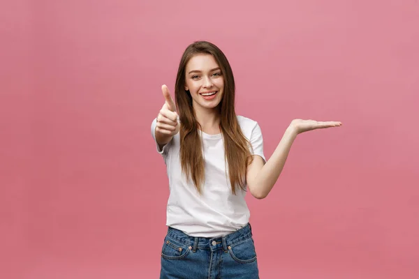 Foto de close-up de sorrir menina bonita mostrando gesto polegar para cima. Feminino isolado sobre fundo rosa no estúdio. — Fotografia de Stock
