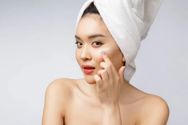 Concetto di salute e bellezza - Attraente donna asiatica che applica la crema sulla sua pelle, isolata sul bianco. — Foto Stock