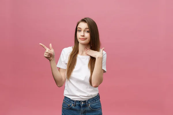 Detailní záběr vážné přísné mladé ženy nosí bílou košili vypadá vystresovaně a ukazuje nahoru s prstem izolované přes růžové pozadí — Stock fotografie