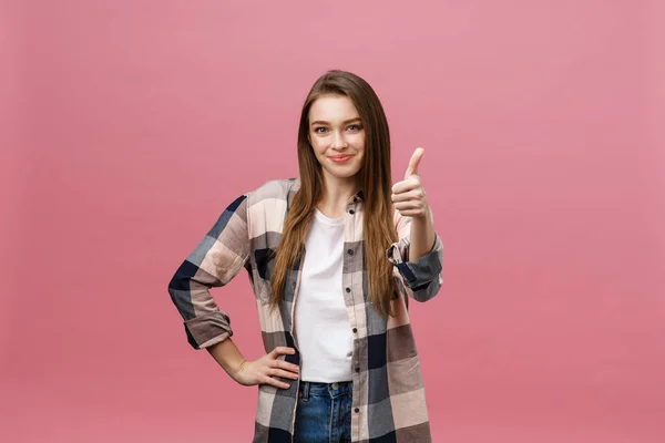 Close-up shot of smiling pretty girl showing thumb up gesture. Female isolated over pink background in the studio. — Stock Photo, Image