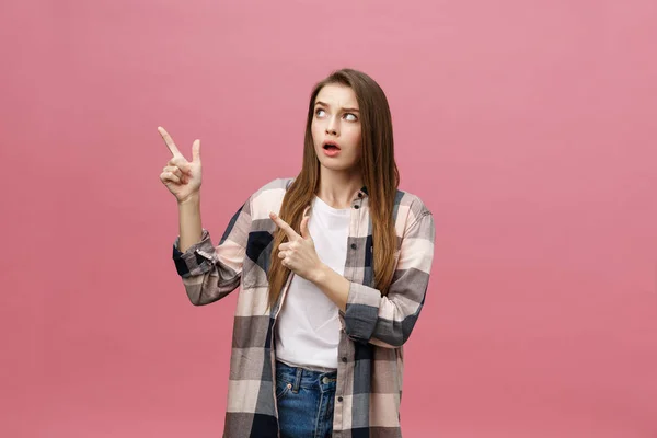 Portrait female pointing with finger with copy space for text or product, looking at the camera with serious expression. Advertising concept — Stock Photo, Image