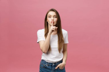 Pembe duvara dudaklarında parmak olan kadın portresi