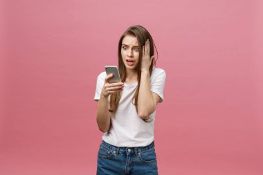 Telefon pink izole bahseden ciddi genç kadın. Kopya alanı ve moda. Yukarı alay