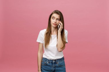 Telefon pink izole bahseden ciddi genç kadın. Kopya alanı ve moda. Yukarı alay.