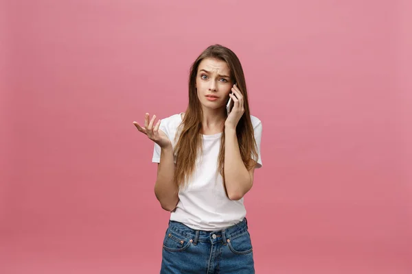 严重的年轻女子在电话交谈隔离粉红色。复制空间和时尚。模拟一下. — 图库照片