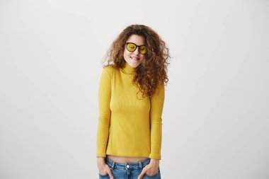 Genç kız kamera gülümseyen mutlu yakın çekim etrafa iskambil izole üzerinde gri duvar ayakta