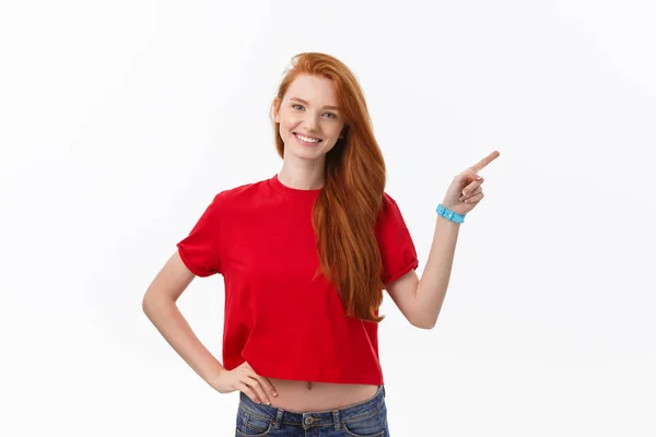 Фото щасливої молодої жінки, що стоїть ізольовано на білому тлі стіни. Перегляд фотоапарата, що показує копійковий простір, що вказує — стокове фото
