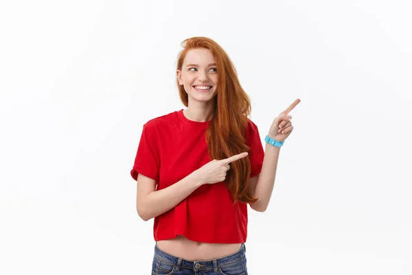 Photo of happy young woman standing isolated over white wall background. Looking camera showing copyspace pointing — Stock Photo, Image