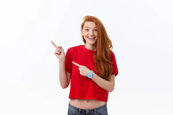 Foto da jovem mulher feliz de pé isolado sobre fundo da parede branca. Olhando câmera mostrando copyspace apontando — Fotografia de Stock