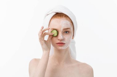 Güzel temiz cilt çekici genç kadın. Beyaz maske ve salatalık. Güzellik bakımı ve kozmetik spa terapisi. Beyaz arka plan