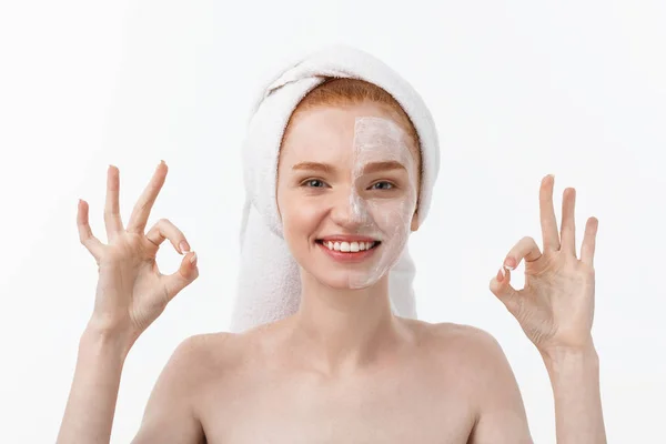 Beauty treatment. Woman applying moisturizing cream skin care product on face, making ok sign studio shot — Stock Photo, Image