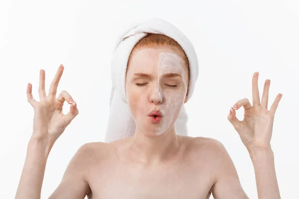 Tratamento de beleza. Mulher aplicando creme hidratante produto de cuidados da pele no rosto, fazendo ok sinal estúdio tiro — Fotografia de Stock