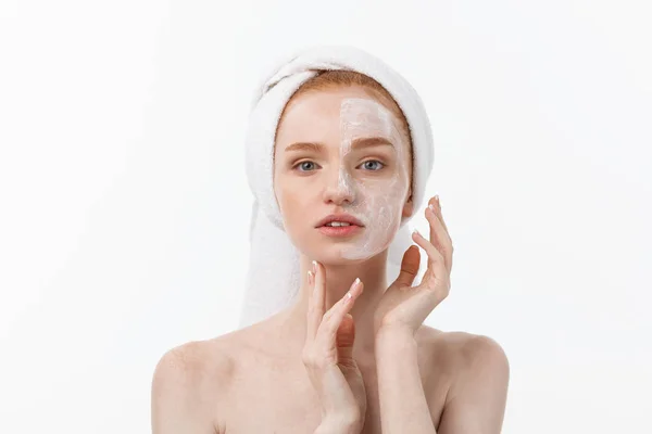 Piękny model stosując Zabieg kosmetyczny krem na jej twarz na białym. — Zdjęcie stockowe
