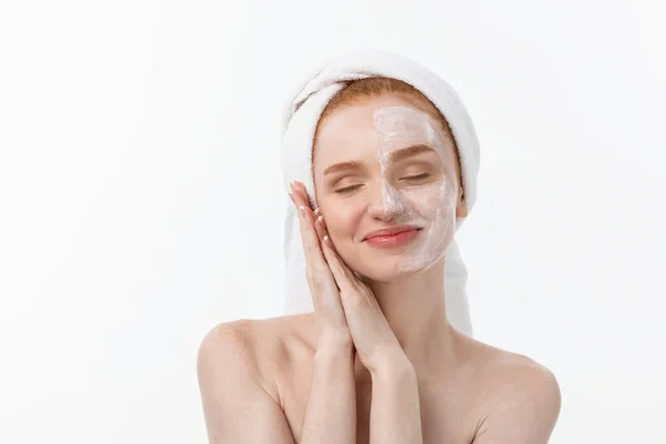 Beautiful model applying cosmetic cream treatment on her face on white. — Stock Photo, Image