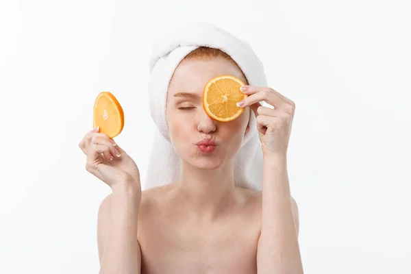 Makanan enak untuk gaya hidup sehat. Wanita muda cantik bertelanjang dada memegang sepotong jeruk berdiri melawan latar belakang putih . — Stok Foto