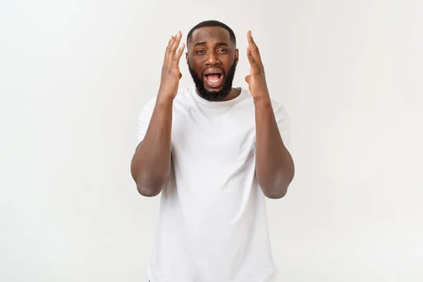 Portret van geschokte jonge Afro-Amerikaanse man het dragen van witte lege T-shirt te kijken naar de camera in verrassing, verbijsterd met een aantal ongelooflijke verhaal. — Stockfoto