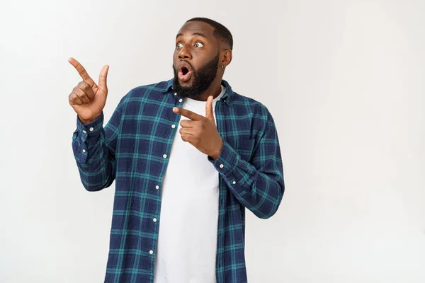 Feliz deleitado dedo delantero masculino en el espacio de copia en blanco, lleva camisa de mezclilla, tiene una sonrisa positiva. Concepto de publicidad y etnia — Foto de Stock