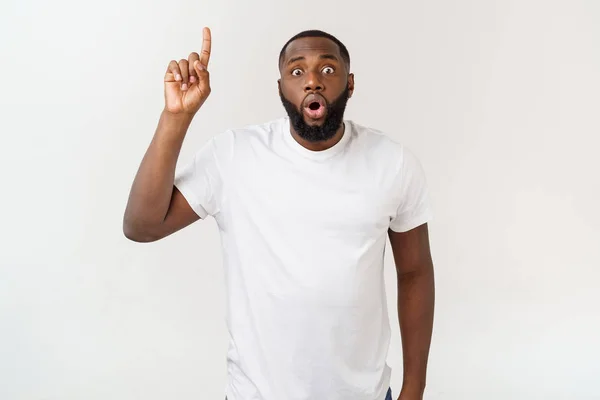 Jonge verbaasd Afro-Amerikaanse wijzend zijn vinger op witte achtergrond met kopieerruimte voor uw advertentie — Stockfoto
