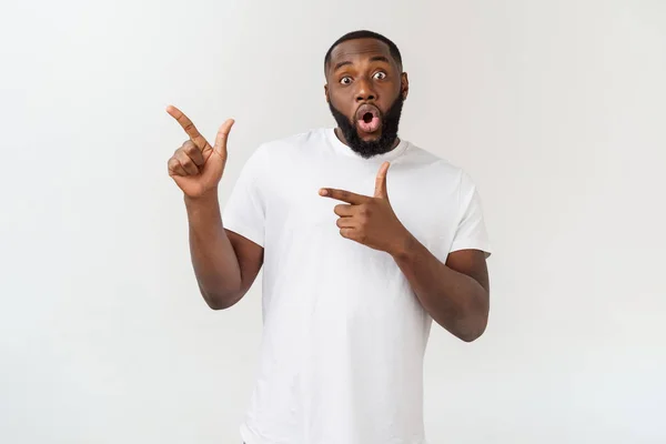 Jonge verbaasd Afro-Amerikaanse wijzend zijn vinger op witte achtergrond met kopieerruimte voor uw advertentie — Stockfoto