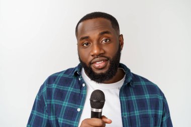 Genç yakışıklı Afro-Amerikan çocuk beyaz arka plan üzerinde izole mikrofon ile duygusal şarkı.