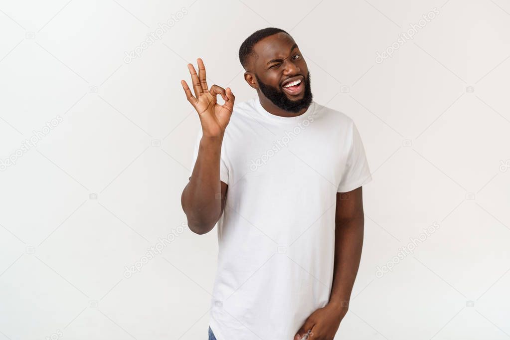 Portrait of happy african-american man showing ok sign and smiling, over white background.