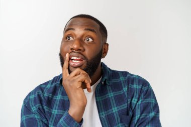 İnsan yüz ifadeleri, duygular ve duygular. Yakışıklı genç Afrikalı-Amerikalı adam düşünceli ve şüpheci ifade ile bakıyor.