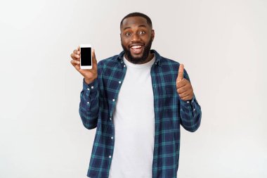 Yakışıklı afro-amerikan adam gri arka plan izole, akıllı telefon sunan.